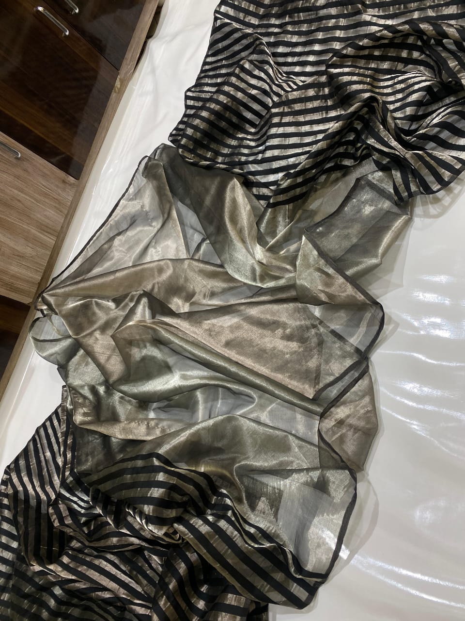 Silver Chanderi Handloom Pattu Tissue Silk Saree With Elegant Black Striped Weaving, Rich Tissue Finish, Stylish Woven Border And Matching Blouse Piece.