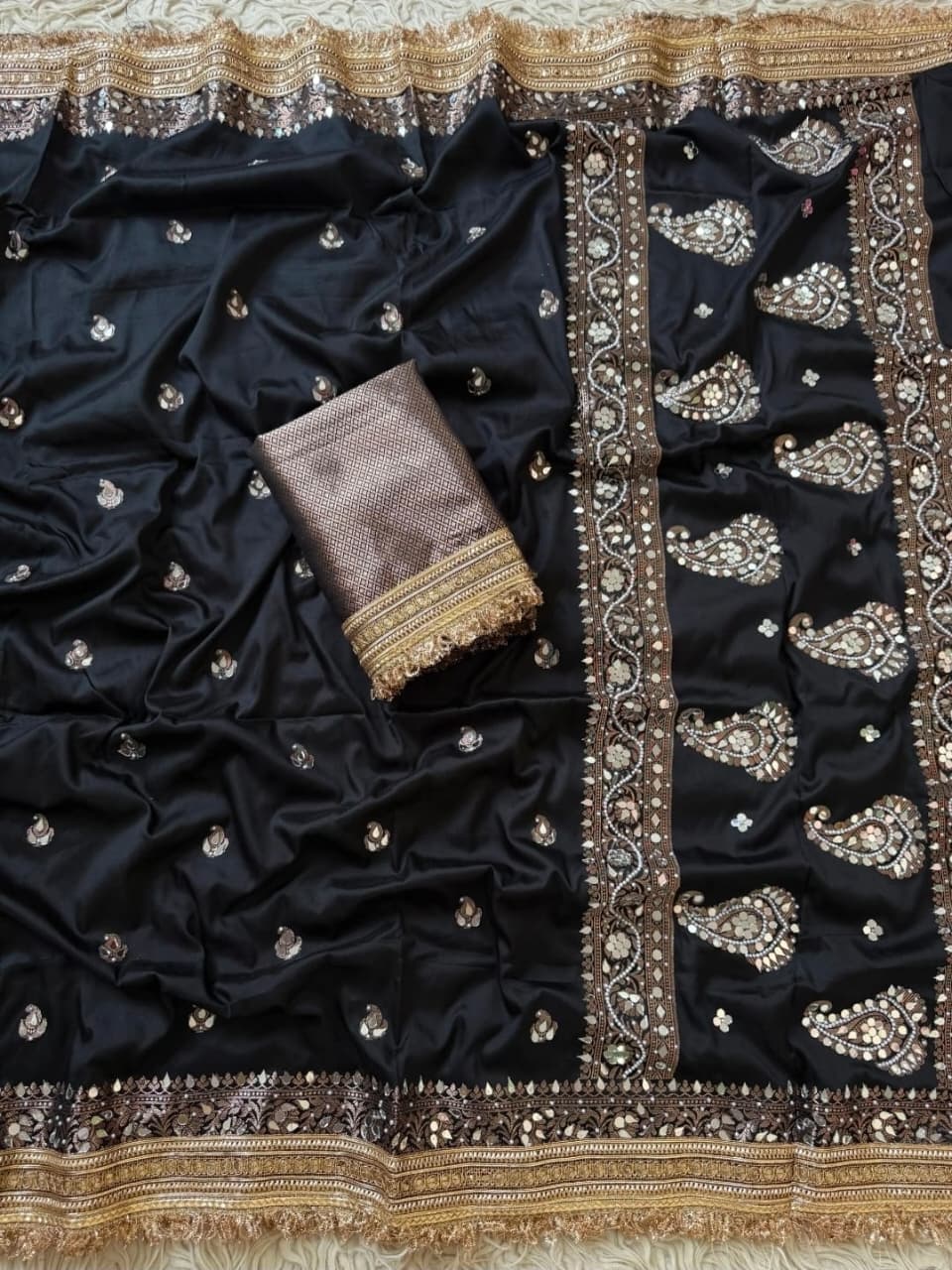 Black Banarasi Soft Silk Woven Saree featuring intricate mirror handwork, elegant Rajkumari lace border, woven paisley motifs, richly embellished pallu, and matching blouse piece, perfect for weddings, festive occasions, receptions, and party wear.