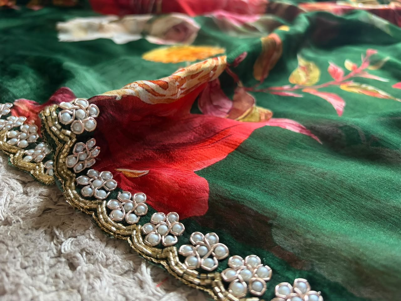 Premium Pure Chinnon Crepe Silk Saree in emerald green with elegant floral digital print, embellished with intricate zardozi, pearl, and cut daana handwork border, paired with a matching Pure Chinnon handwork blouse piece for weddings, festive occasions, and party wear.