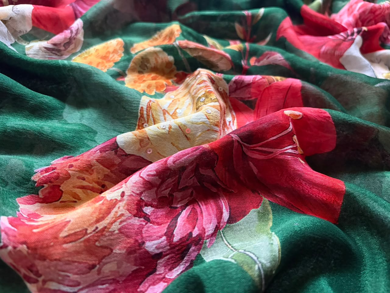 Premium Pure Chinnon Crepe Silk Saree in emerald green with elegant floral digital print, embellished with intricate zardozi, pearl, and cut daana handwork border, paired with a matching Pure Chinnon handwork blouse piece for weddings, festive occasions, and party wear.