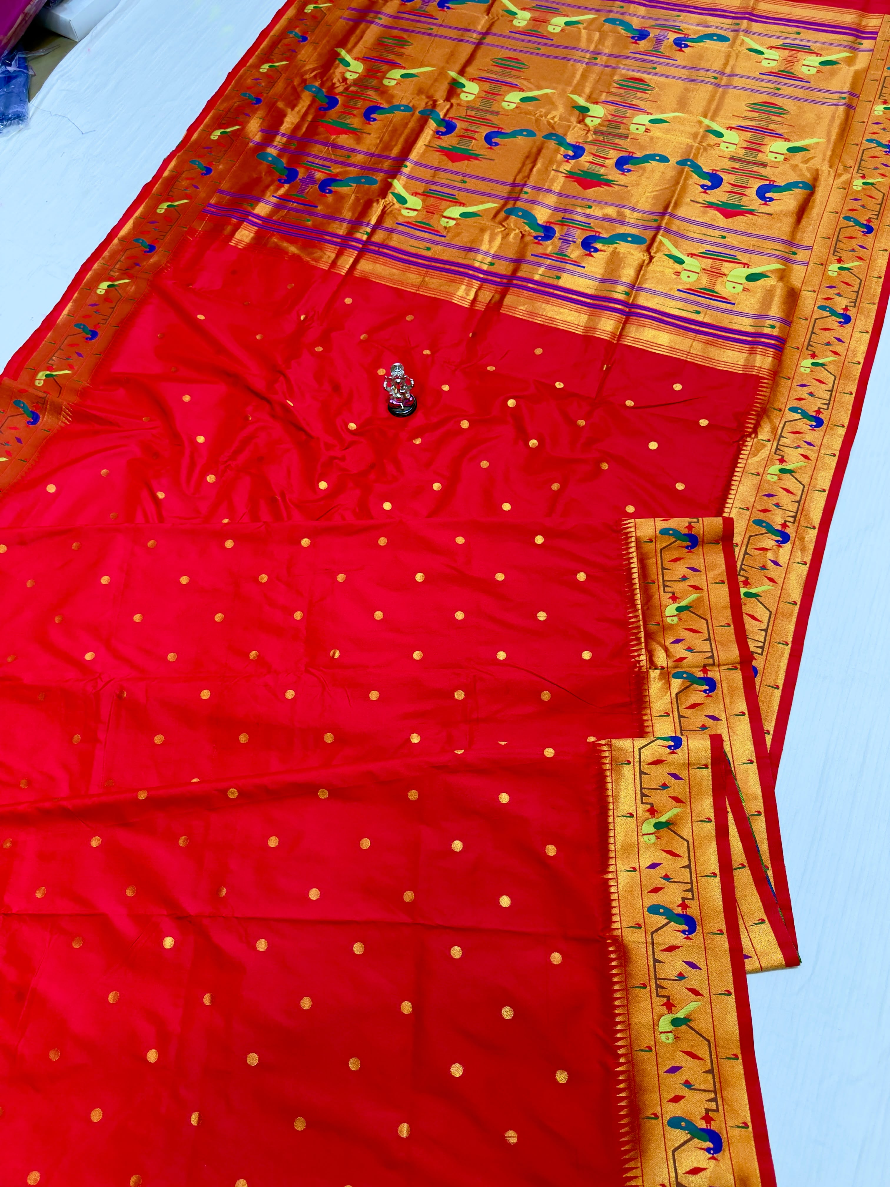 Paithani Saree in premium Katan Silk with a rich Red body, all-over zari butti, traditional Mor Popat brocade pallu and border, and exclusive running blouse piece, perfect for weddings, festive occasions, and traditional wear.